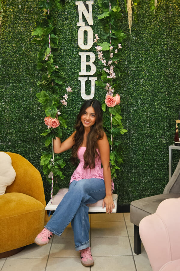 Model with salon branding behind her at a Costa Rica esthetics studio, vertical framing