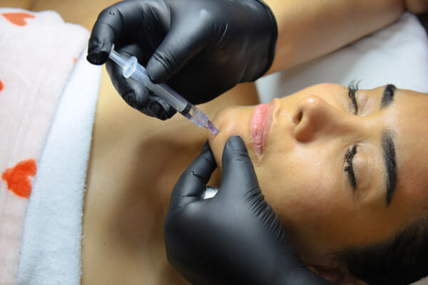 Studio owner applying skincare product at a Costa Rica esthetics salon, hands-on close-up in natural light