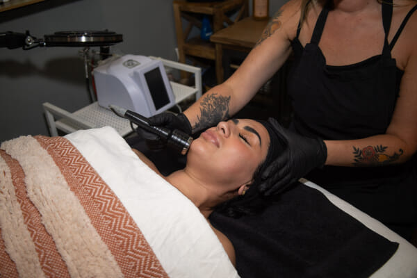 Esthetician performing facial application at a North Park San Diego salon, treatment in progress