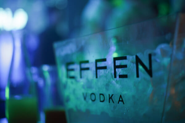 The EFFEN Vodka logo etched on a glowing block of ice under blue and green nightclub lighting.